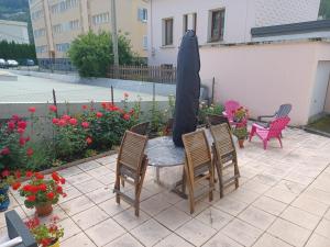 einen Tisch mit Stühlen und einem Sonnenschirm auf einer Terrasse in der Unterkunft Appartement 6 pers, LA VANOISE, GARAGE motos vélos in Fourneaux