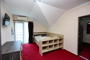 a small room with a bed and a window at Pensiunea Celestin in Eşelniţa