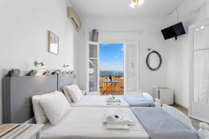 a room with two beds with a view of the ocean at Unforgettable Return To Timeless Spetses in Spetses