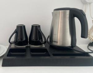 una tetera y dos tazas en una bandeja negra en La Villa Rooms en Mykonos ciudad