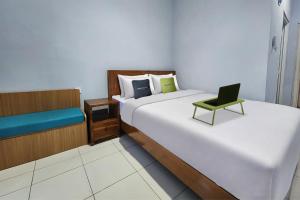 a room with two beds with a laptop on it at Urbanview Hotel Mutiara Persada Syariah Majalengka by RedDoorz 