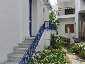 una escalera que conduce a un edificio blanco con barandilla azul en Η Ελπίδα και η Γιάννα ξεκίνησαν ένα χώρο cute, en Volos