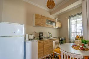a kitchen with a white refrigerator and a table at Frida appartment in Preveza