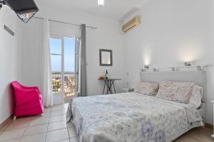 a white bedroom with a bed and a balcony at Unforgettable Return To Timeless Spetses in Spetses +6 photos