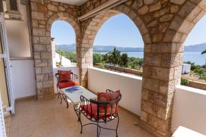 a balcony with tables and chairs and a view of the water at Voula Resort in Elafonisos