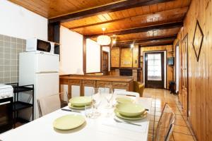 y cocina con mesa, sillas y nevera. en Chalet Casa dei Nonni, en Ceppo Morelli