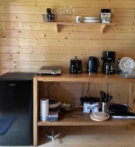 a kitchen with wooden walls and a counter with a microwave at Dagö Berry suvemaja in Hiiumaa