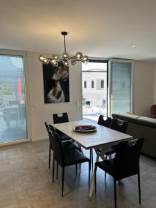 a dining table and chairs in a living room at LabPark Terrace in Melano