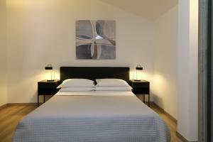 1 dormitorio con 1 cama grande y 2 mesitas de noche en Appartamenti Alighieri, en Bardolino