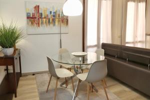 comedor con mesa de cristal y sillas en Appartamenti Alighieri, en Bardolino