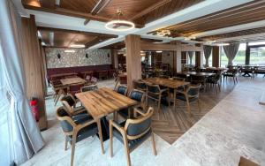 un restaurante con mesas de madera y sillas en una habitación en Hôtel Restaurant & Spa Les Planets en Les Rasses