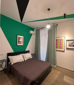 1 dormitorio con cama y pared verde en The B Place Cola, en Roma