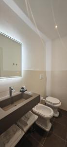 y baño con aseo y lavabo con espejo. en The B Place Cola, en Roma