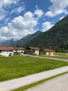 une route avec des maisons et des montagnes en arrière-plan dans l'établissement Gästehaus Huber, à Holzgau