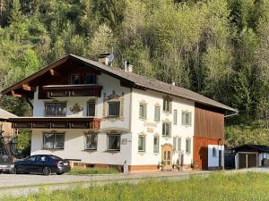 a large house with a car parked in front of it at Gästehaus Huber in Holzgau