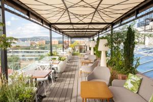 einen Balkon mit Stühlen und Tischen sowie Stadtblick in der Unterkunft Mystery Hotel Budapest in Budapest