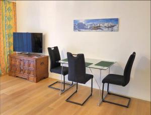 a dining room with a table and chairs and a tv at Gemuetliche 2 Zimmer Wohnung mit Gartensitzplatz in Fällanden