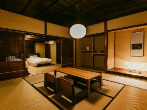 a living room with a table and a bed at 龍野城下町古民家ホテル kurasu in Tatsuno