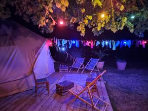 a group of chairs sitting under a tent at night at Le Bivouac in Cabariot
