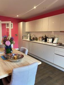 a kitchen with a wooden table and white cabinets at Sublime waterfront retreat with private terrace in Bristol