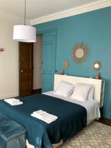 ein blaues Schlafzimmer mit einem großen Bett mit Handtüchern darauf in der Unterkunft La Grande Maison Mazamet in Mazamet