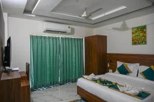 a bedroom with two beds and a green curtain at Hotel 7 Heaven in Dehradun