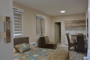 Cet appartement comprend une chambre avec un lit et une table ainsi qu'une cuisine. dans l'établissement Garden apartmani, à Jagodina