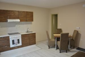 uma cozinha e sala de jantar com uma mesa e um lavatório em Garden apartmani em Jagodina