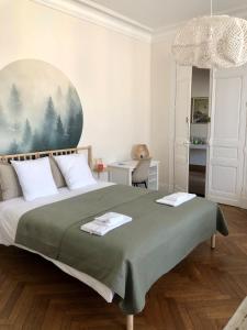 La Grande Maison Mazamet في مازامي: غرفة نوم بسرير كبير مع بطانية خضراء