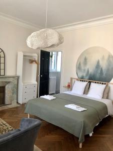 La Grande Maison Mazamet في مازامي: غرفة نوم بسرير كبير ومدفأة