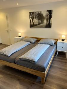 a bedroom with a large bed with two lamps on it at Ferienwohnung Ahrblick in Schuld