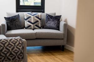 un divano in soggiorno con cuscini di Chic Apartments and Studios at The Point in Aberdeen ad Aberdeen