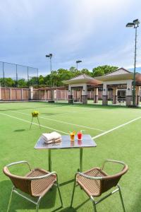 a table and two chairs on a tennis court at The Empire Brunei in Bandar Seri Begawan