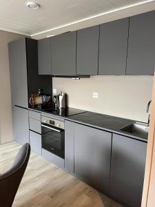 kuchnia z czarno-białymi szafkami i zlewem w obiekcie Exclusive Apartment w mieście Stryn