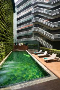 a building with a swimming pool in front of a building at Cross Vibe Chiang Mai Decem Nimman Hotel - formerly X2 Vibe Chiang Mai Decem - SHA Extra Plus in Chiang Mai