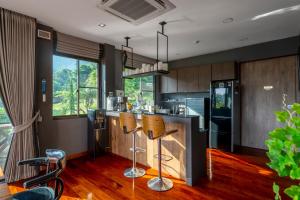 a kitchen with a bar with chairs and a refrigerator at President R1-3 The Height Khaoyai 3BR byน้องมังคุด in Ban Huai Sok Noi