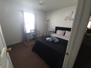 un dormitorio con una cama con un animal de peluche en Emerald Guest Room 2C, en Newark