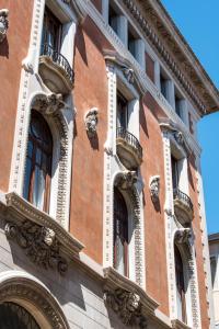 a brick building with windows and balconies on it at Nolinski Venezia - Evok Collection in Venice