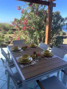 a wooden table with plates of food on it at Casa Nocilla, un dammuso sul mare! in Pantelleria