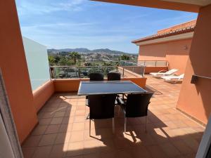 a balcony with a table and chairs on a roof at Apartamentos Flamingo Hills in Benitachell