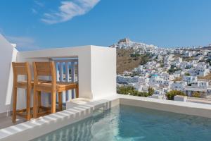 a villa with a swimming pool and two chairs at Korali in Astypalaia