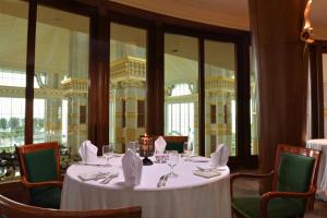 a dining room with a white table and chairs at The Empire Brunei in Bandar Seri Begawan