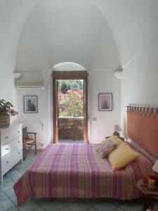 a bedroom with a large bed and a window at Casa Nocilla, un dammuso sul mare! in Pantelleria