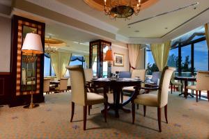 a dining room with a table and chairs and windows at The Empire Brunei in Bandar Seri Begawan