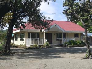 a small yellow house with a red roof at Villa in Pagudpud