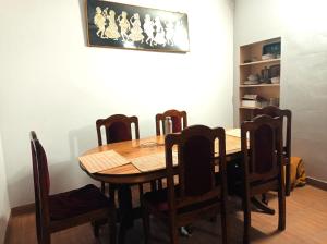a dining room with a wooden table and chairs at The Pine View Home Stay in Almora