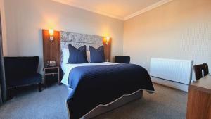 um quarto de hotel com uma cama grande e uma cadeira em Hotel Ocean em Great Yarmouth