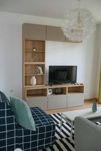 a living room with a couch and a tv at Apartment next to Mall Plovdiv in Plovdiv