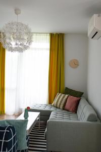a living room with a couch and a chandelier at Apartment next to Mall Plovdiv in Plovdiv