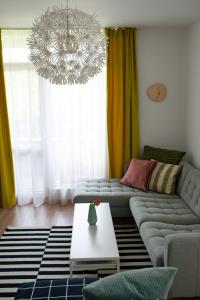 a living room with a couch and a chandelier at Apartment next to Mall Plovdiv in Plovdiv